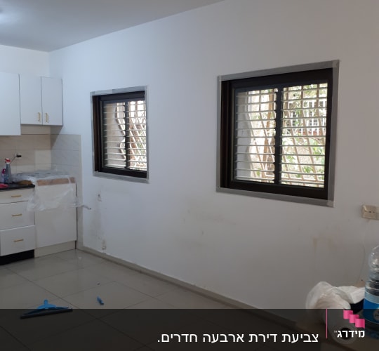 קיר צבוע בלבן עם סימני לכלוך וגליל ניילון